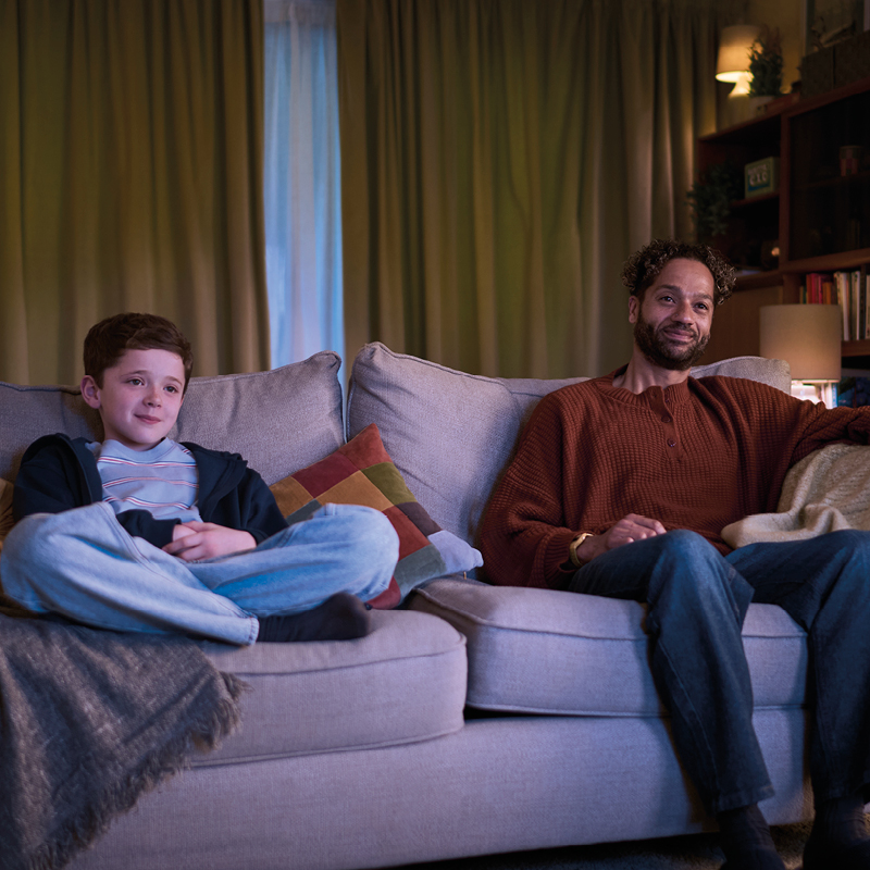 Man and boy on couch watching tv