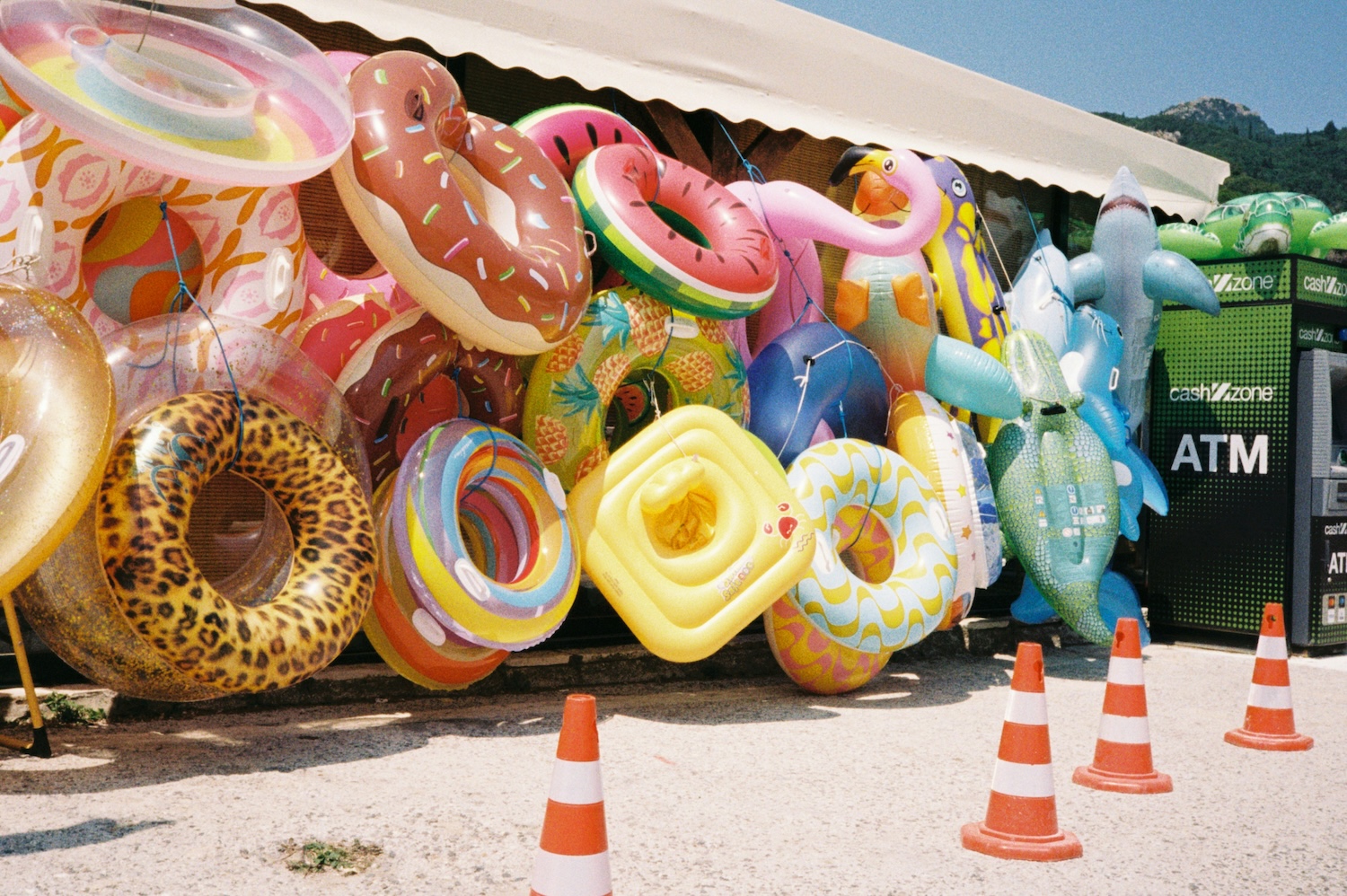 Pool floats are stacked up near an atm.