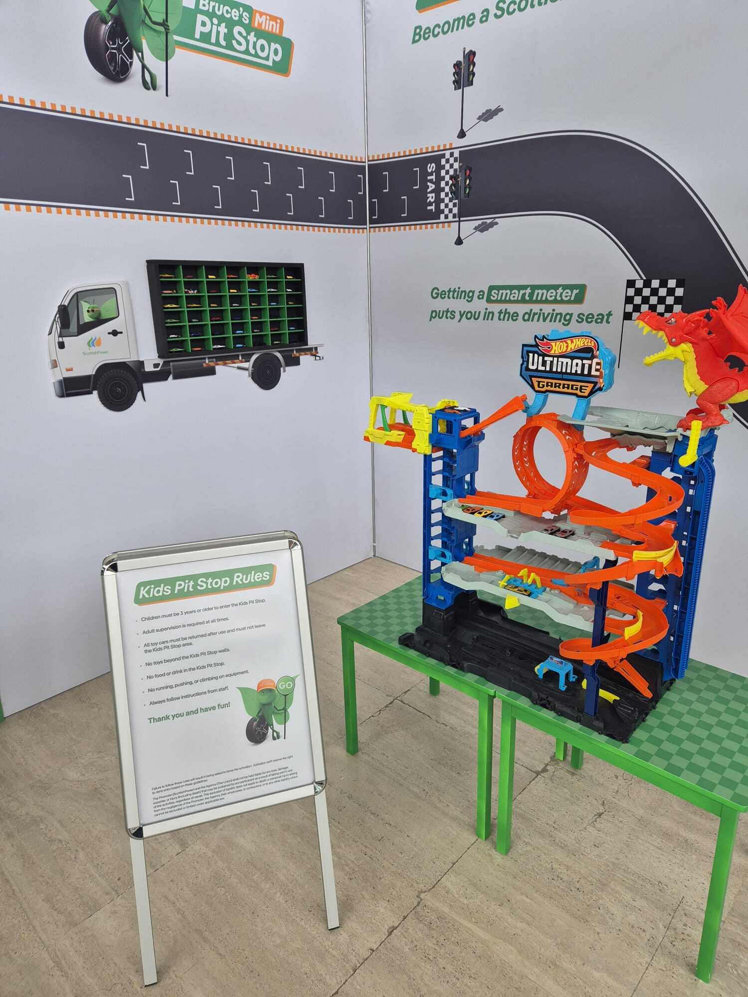 display stand with Scottish Power rules for game and toy car set on table